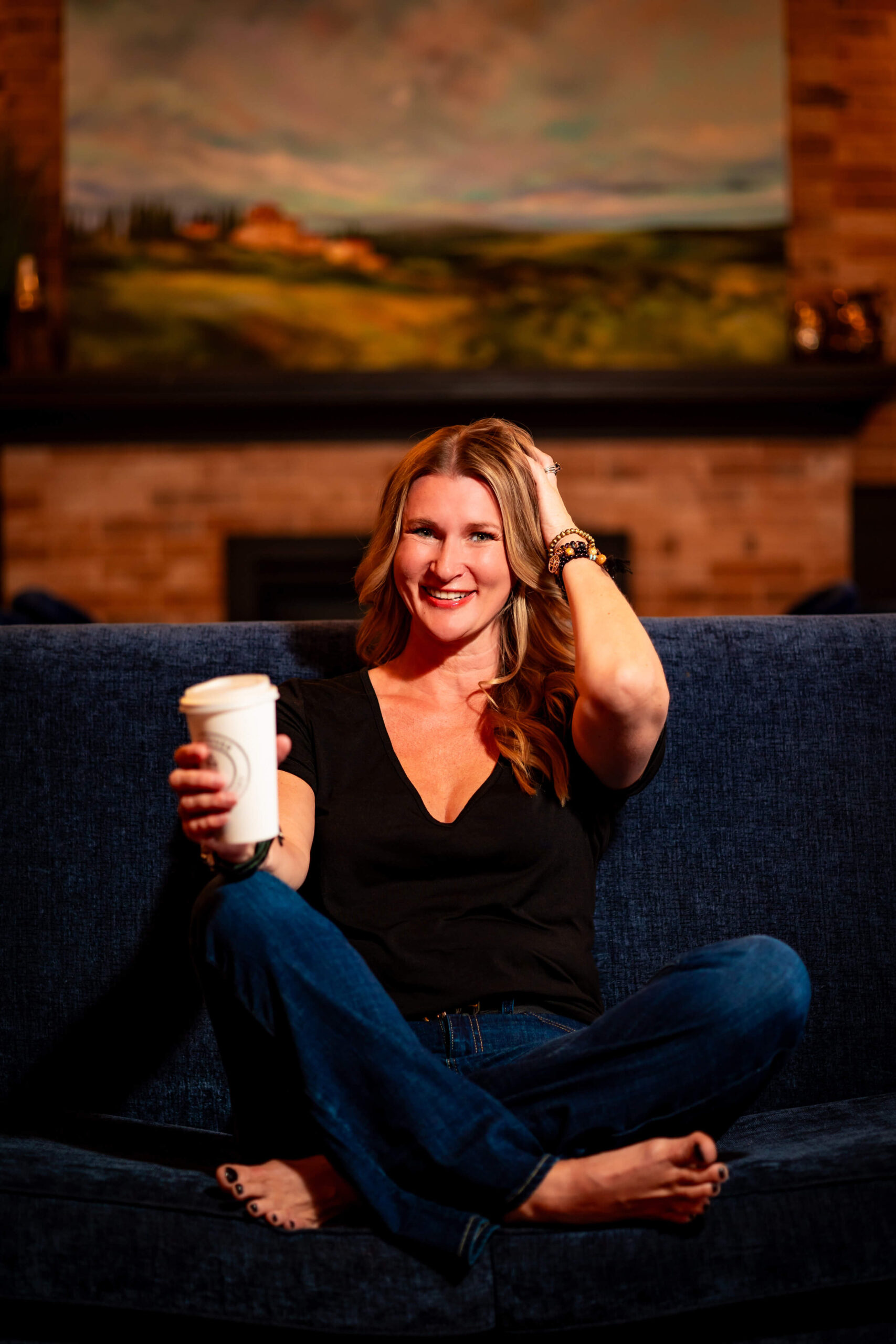 Relaxed businesswoman enjoying a coffee break during a branding photoshoot.