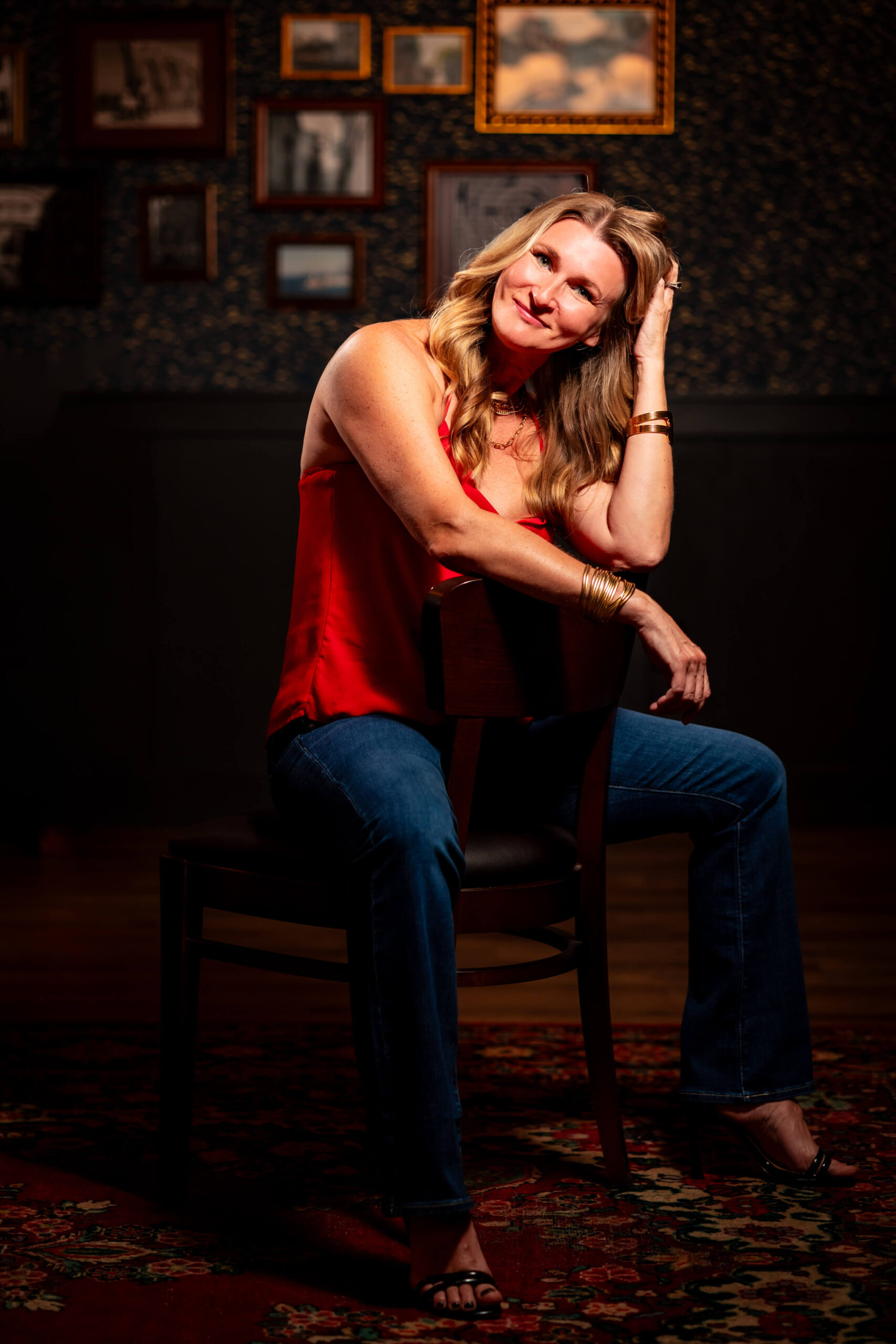 Callie Croken, a life and business coach, sitting poised and professional in front of unique wall frames during her branding photoshoot with Lake Design.