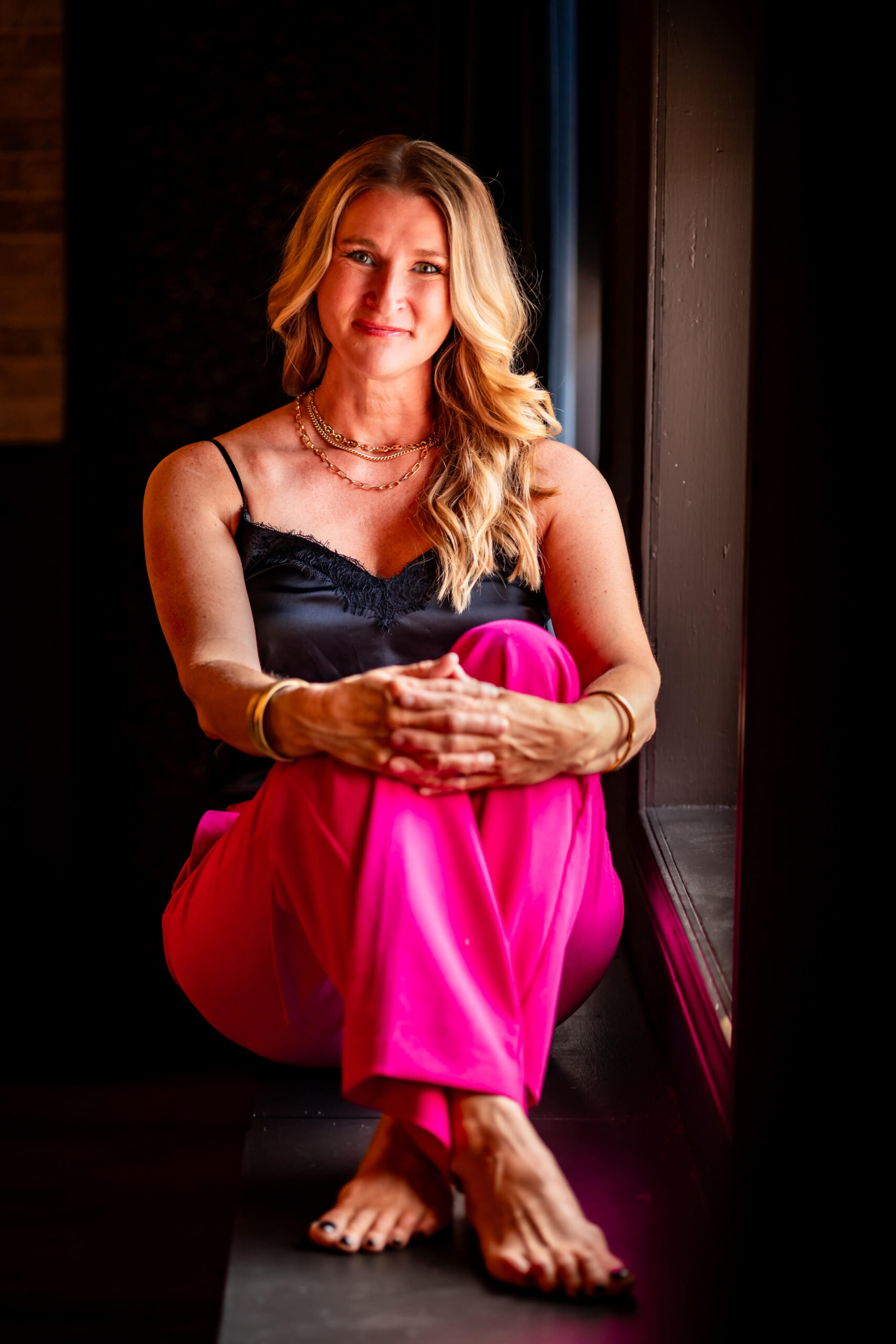 Callie Croken, a life and business coach, sitting confidently in a window sill during her branding photoshoot with Lake Design.