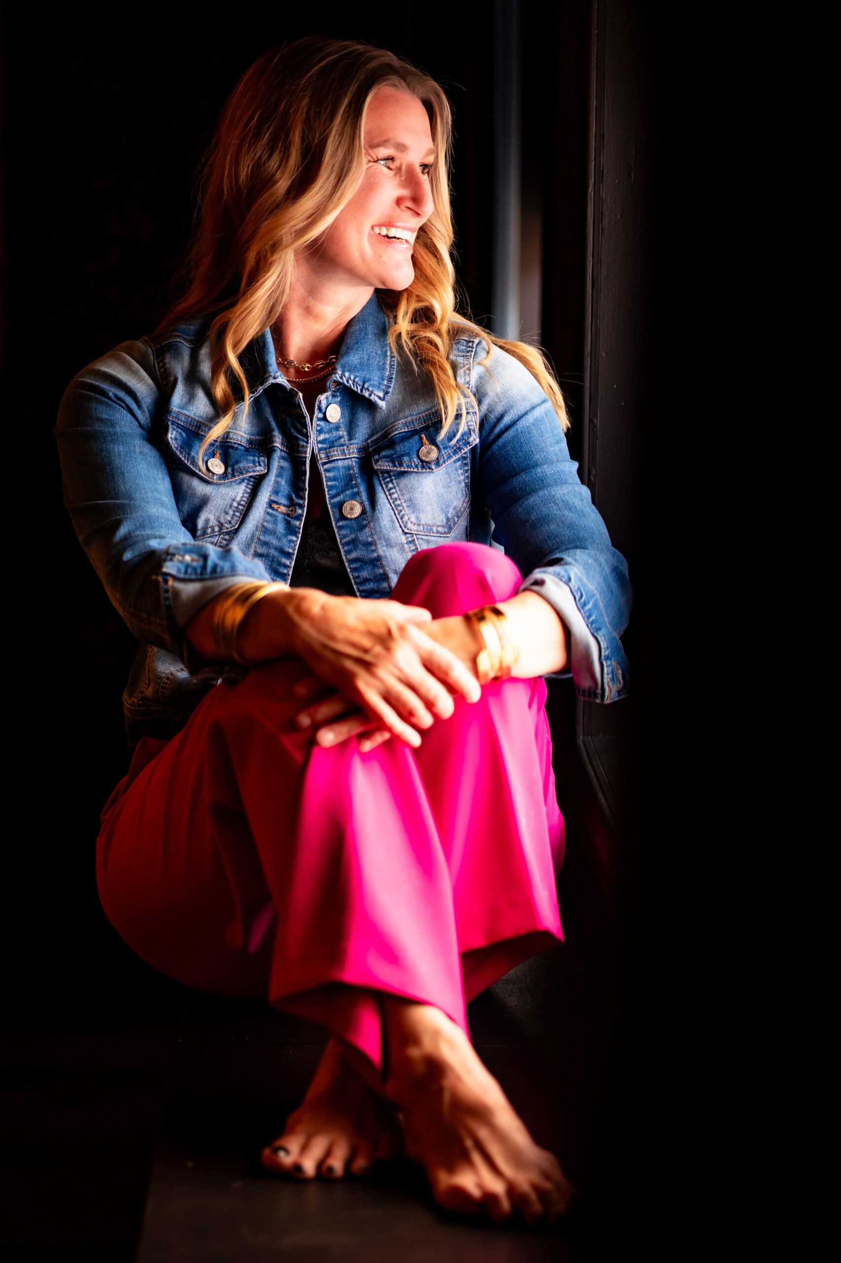 Callie Croken, a life and business coach, sitting warmly in a window sill during her branding photoshoot with Lake Design.