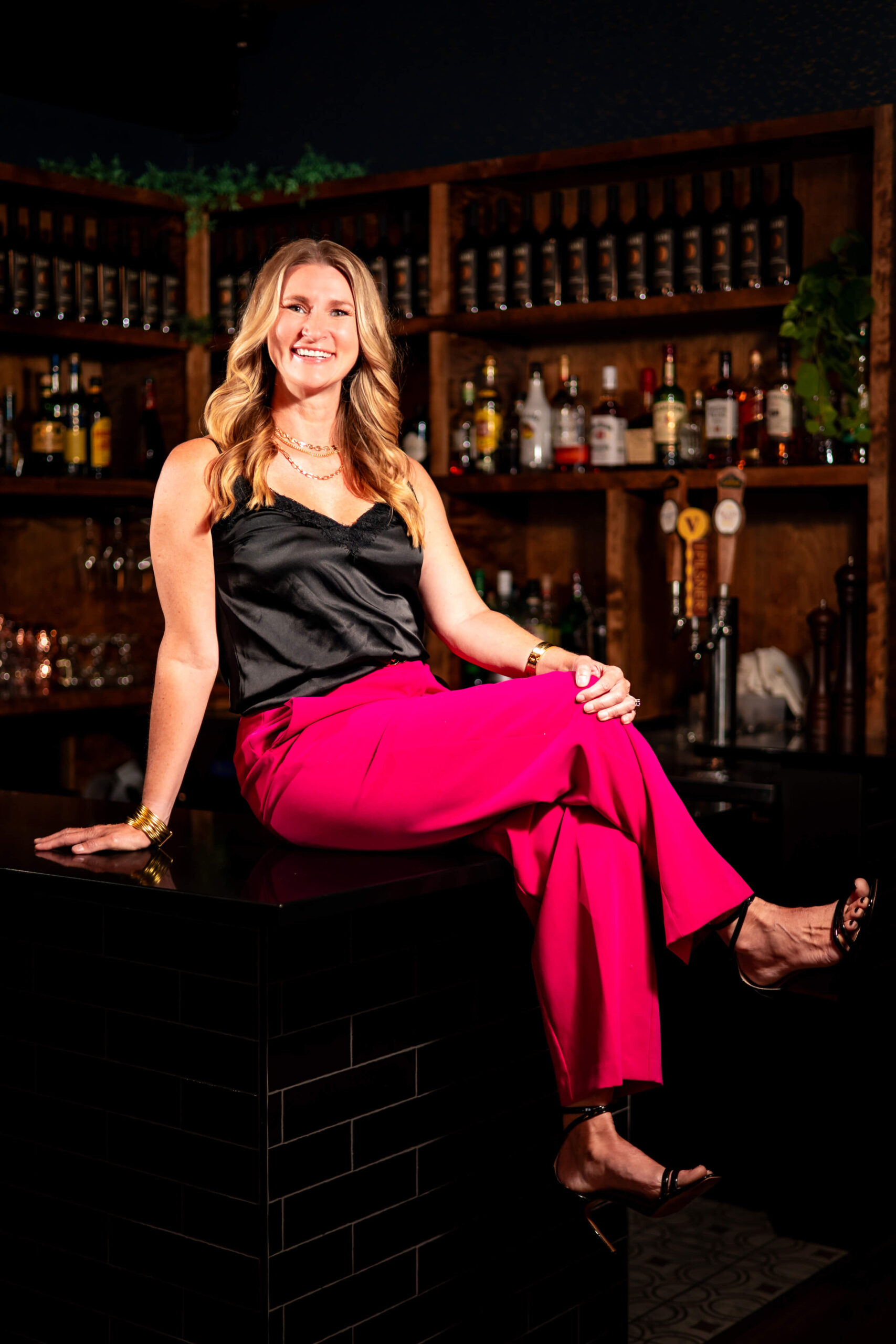 Callie Croken, a life and business coach, sitting poised on a bar during her branding photoshoot with Lake Design.