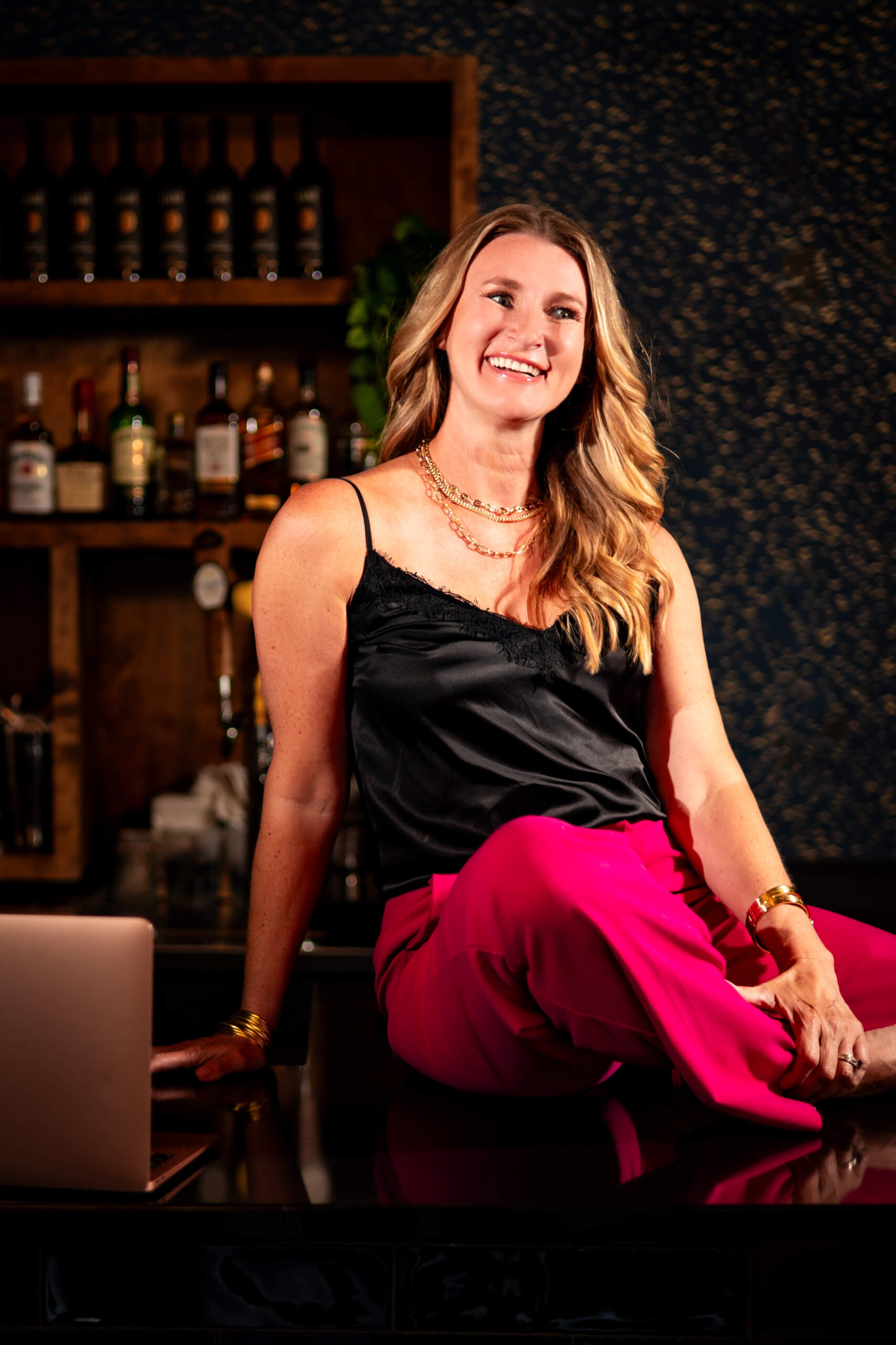 Callie Croken, a life and business coach, sitting confidently on a bar during her branding photoshoot with Lake Design.